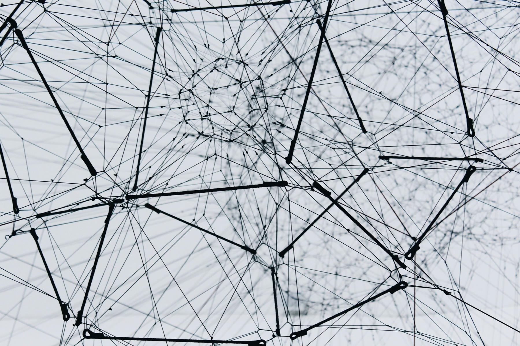 Interconnected network of nodes and lines against a pale sky
